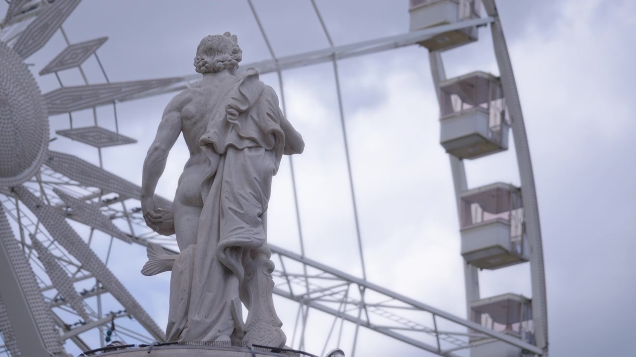 Mannlig skulptur og roterende pariserhjul
