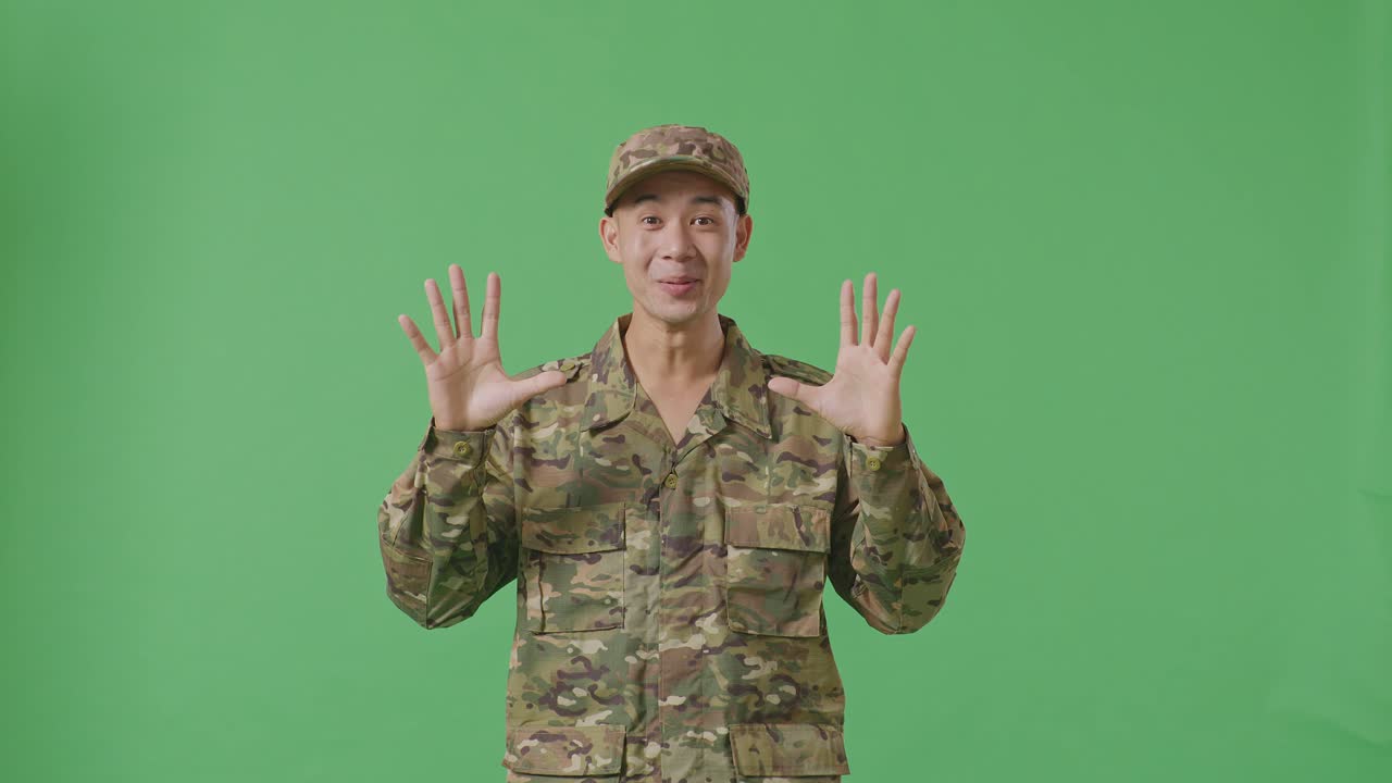 Asian Man Soldier Smiling And Saying Wow While Standing In The Green Screen Background Studio