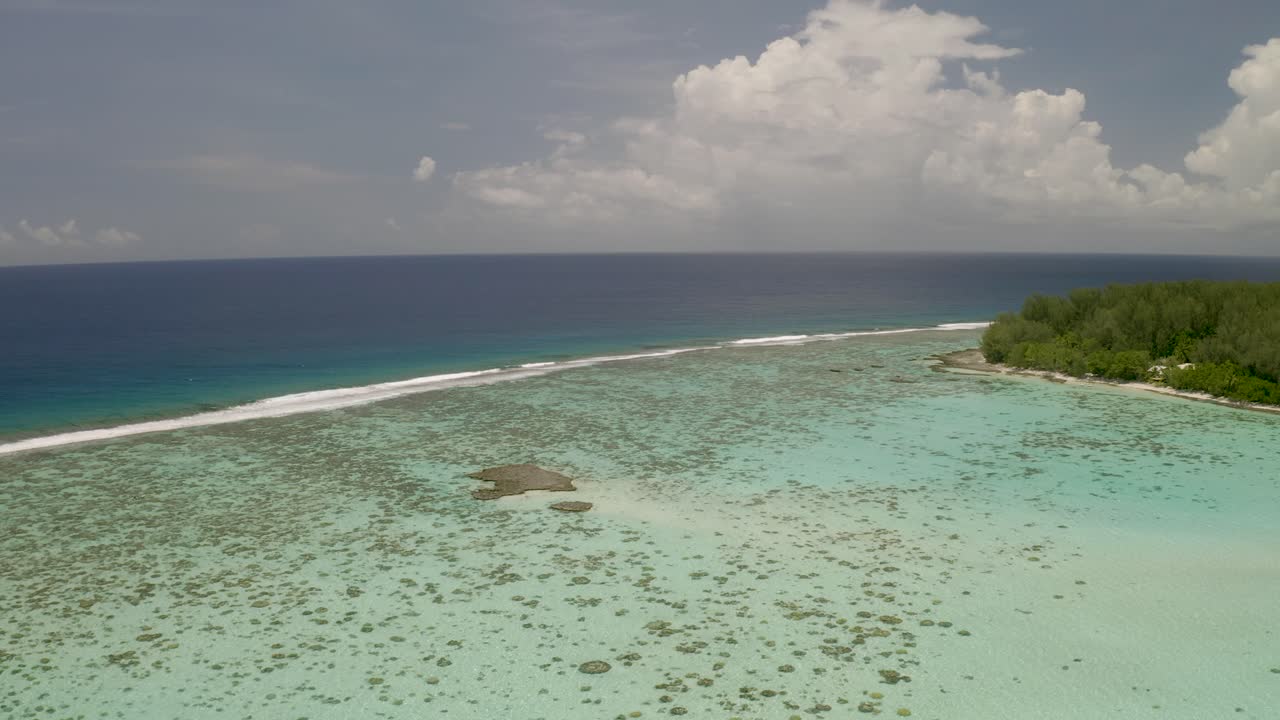 Ripresa aerea panoramica che rivela una piccola isola nel mezzo della barriera corallina che circonda l'isola di Mo'orea.