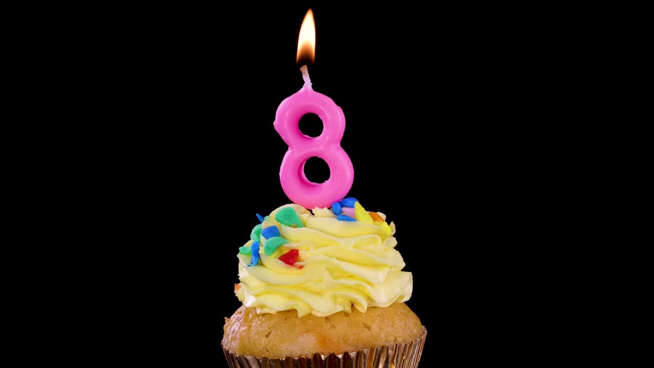 File di cupcake sormontati da candele rosa a forma di numero otto sono disposte su uno sfondo nero, con ogni candela accesa, creando un'atmosfera celebrativa e giocosa.