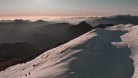 Se-Pueden-Ver-Claramente-Todas-Las-Cadenas-Montañosas,-Desvaneciéndose-Una-Tras-Otra-Hacia-El-Horizonte,-El-Sol-Brilla-Con-Fuerza-Contra-La-Nieve,-Cubriendo-El-Paisaje-De-Luces-Y-Sombras