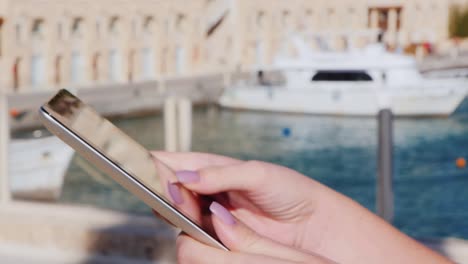 hands with the tablet on the background of yachts