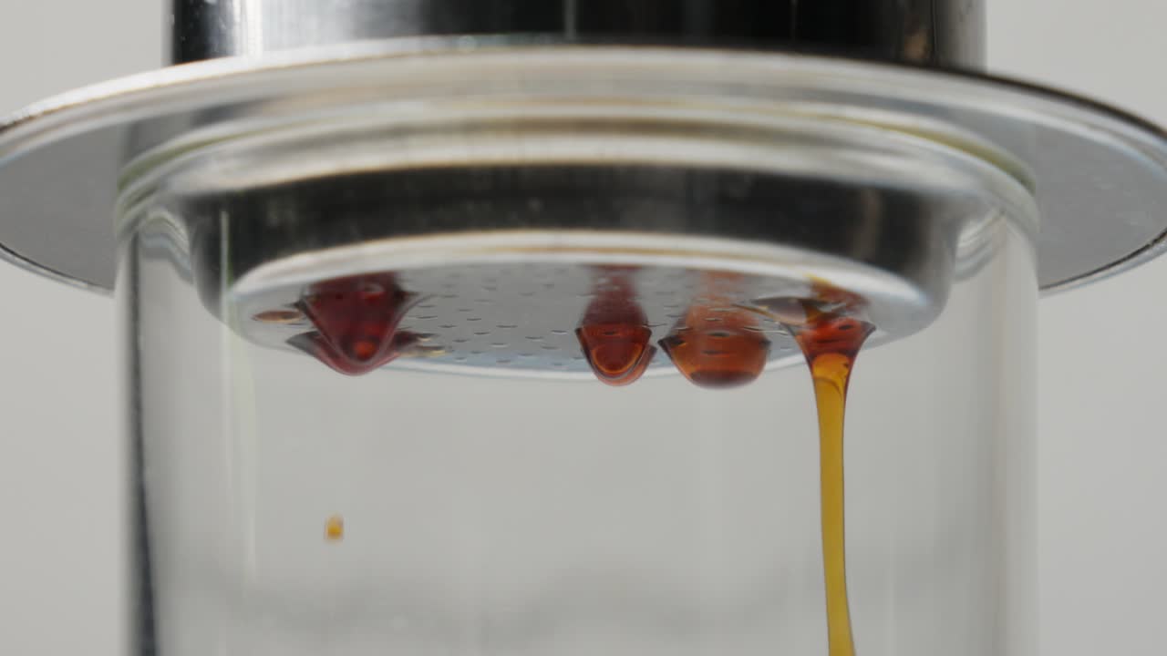 커피는 어두운 갈색 카라멜화 된 액체와 함께 베트남 드립 글래스를 안개