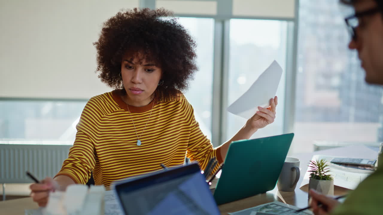 Busy coworkers doing paperwork together sitting laptops workplace closeup