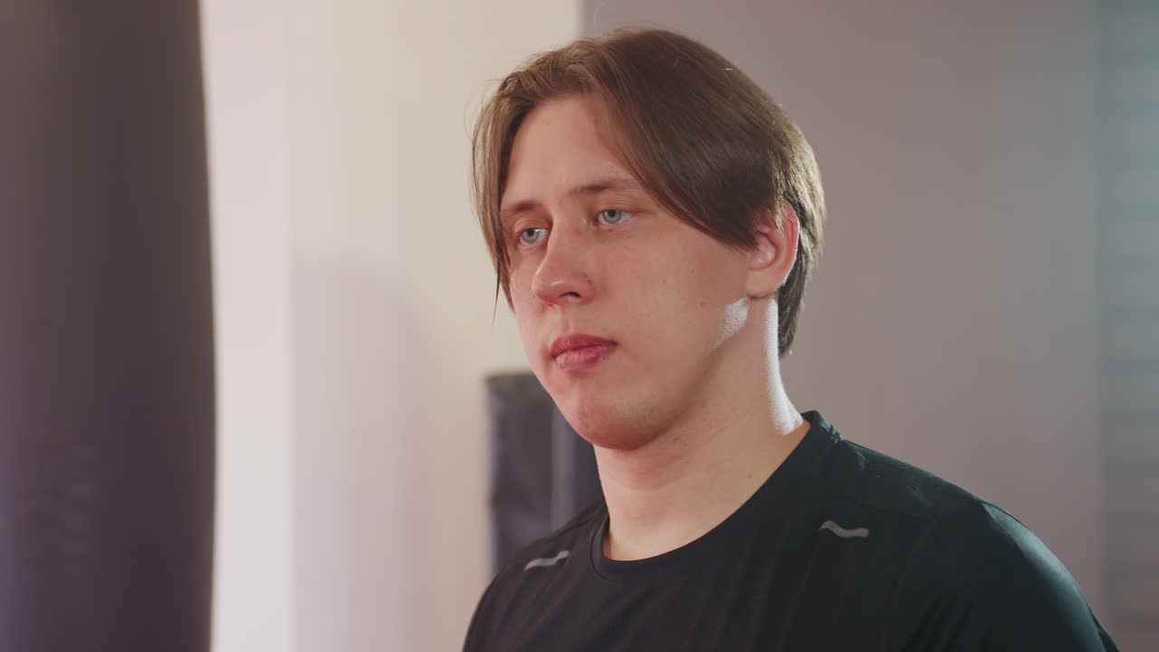 Two fighters face each other inside gym, maintaining strong eye contact filled with tension, focus, determination, preparation, competition, challenge, and mental strength, symbolizing confrontation