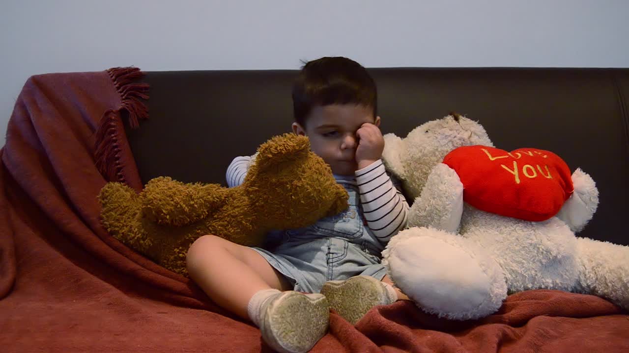 귀여운 피곤한 유아가 소파에서 잠이 들었습니다 - 재미있는 아기 얼굴 표정