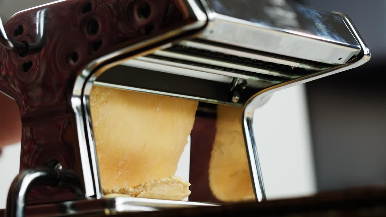Close-up of Pasta Dough Being Rolled Through a Manual Machine