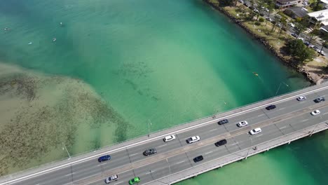 coches que viajan en el puente tallebudgera creek sobre el agua azul turquesa - gold coast, queensland, australia