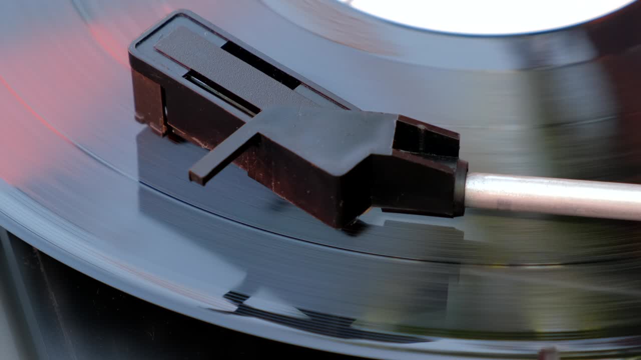 ручка стилуса и игла опускаются на черную виниловую пластинку на диджейском поворотном столе. антикварный проигрыватель записей. вращающаяся пластинка и стилус с иглой. тенденции 60-х, 70-х, 80-х, 90-х. крупный план, 4k, крупный, макро