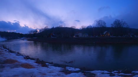 Timelapse-Del-Anochecer-A-Fines-Del-Invierno-En-Una-Pequeña-Ciudad-De-América,-Sobre-Un-Río-Con-Algo-De-Nieve-Todavía-En-El-Suelo-Y-Cielos-Coloridos-Y-Nubes-En-El-Estado-De-Nueva-York-En-Rosendale,-Condado-De-Ulster,-Valle-De-Hudson