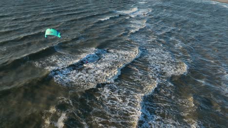 tomada panorámica de un kitesurfista jugando en el