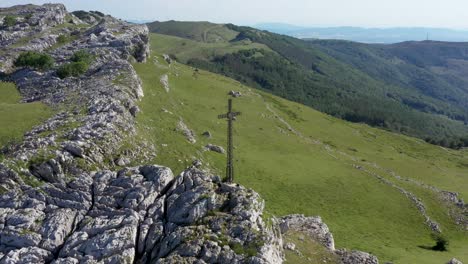 vista aérea de drones de una gran cruz de hierro en la cima de una montaña en el país vasco