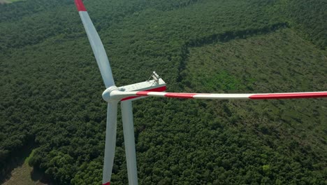 Turbina-Eólica-Contra-Un-Campo-Verde-Y-Exuberante---Primer-Plano-Aéreo