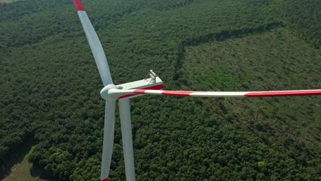 turbina eólica contra un campo verde y exuberante - primer plano aéreo