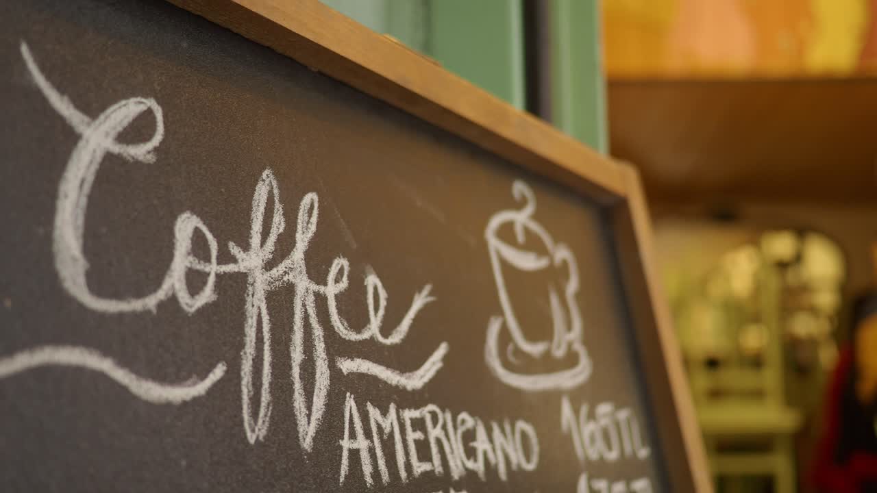 Tavleskilt der reklamerer for kaffe og americano på en café