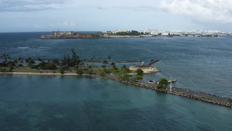 wide aerial push in shot to the old fort on isla de cabra on puerto rico - a popular tourist destination