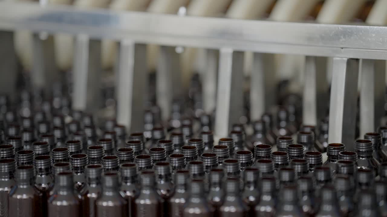 Syrup bottles going through a machine.