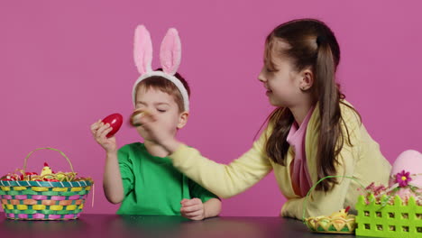 sweet children knocking eggs together for easter tradition in studio,