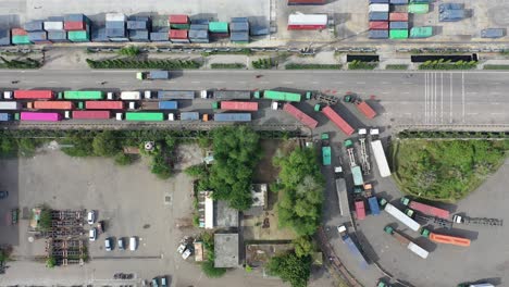 vista aérea de un puerto de navegación ocupado con pilas de contenedores y camiones