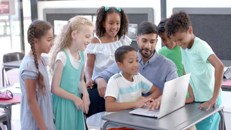 young asian man teaches in a classroom at school, surrounded by students
