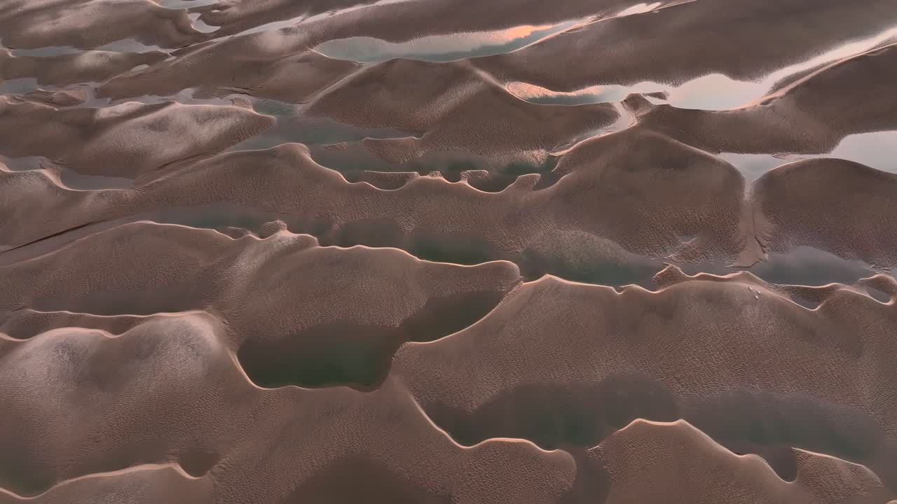 Aerial View of Sand Dunes and Water at Sunset