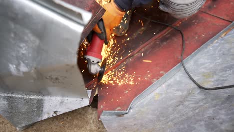 worker cutting sheet metal with angle grinder