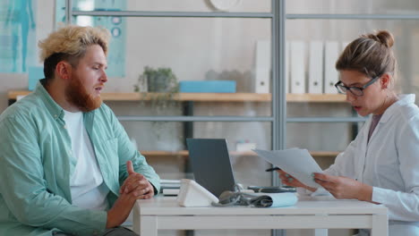 Overweight-Man-Talking-with-Female-Doctor-in-Medical-Office