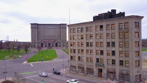 Aerial-past-derelict-buildings-reveals-the-exterior-of-the-abandoned-central-train-station-in-Detroit-Michigan