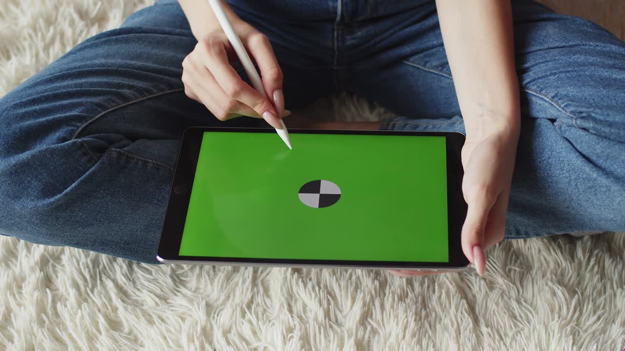 여성 손은 그래픽 태블릿의 크로마키 화면에 스타일러스로 그림을 그립니다. 위쪽 뷰, 클로즈업. 일러스트레이터는 디지털 펜을 사용하여 디지털 태블릿에 그림을 그리습니다. 컨셉 아트