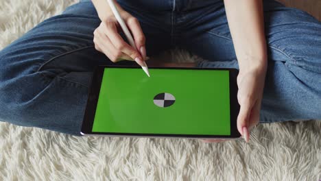 las manos de las mujeres dibujan con el lápiz en la pantalla chromakey de la tableta gráfica, vista superior, primer plano. el ilustrador dibuja en la tableta digital usando el bolígrafo digital. arte conceptual