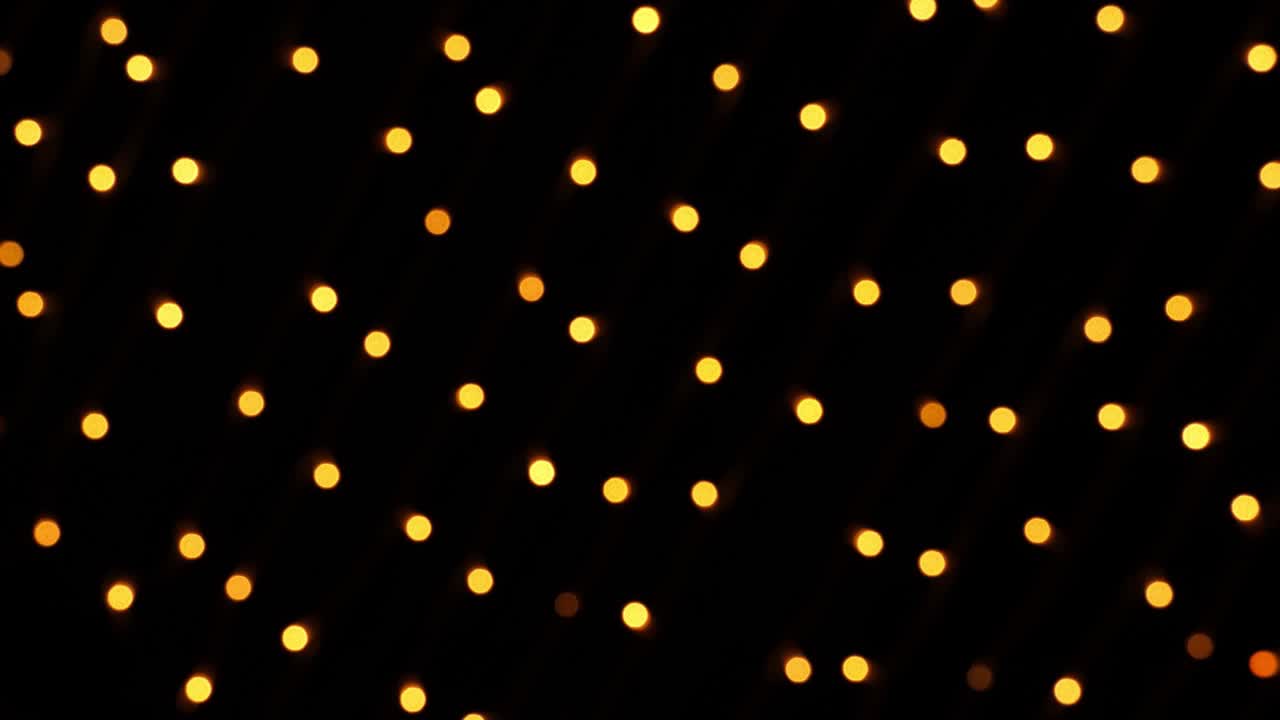 Abstract bokeh background in motion. shining, blurred golden particles, lights. bright bokeh from garlands on dark background. New year or Christmas festive backdrop
