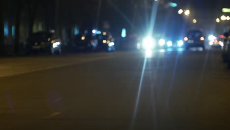 tráfico callejero urbano nocturno de la ciudad. coches a la luz de faros y linternas