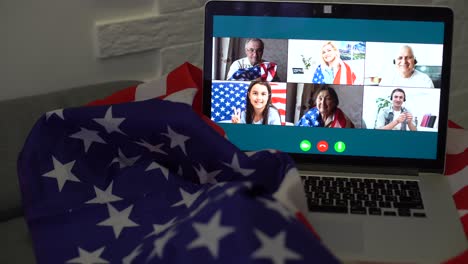 american or usa national flag. working from home on computer notebook laptop on webcam video call conference in quarantine.