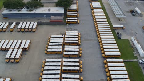 vista de avión no tripulado de una fila de autobuses escolares amarillos en un gran estacionamiento