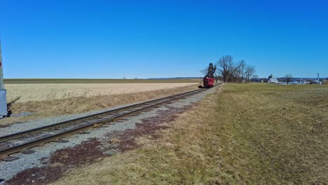 a rail car traveling along a lonely track on a sunny winter day