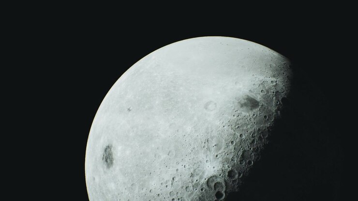 Vista da superfície da lua mostrando crateras e detalhes durante a noite
