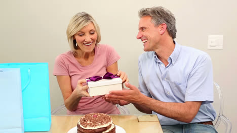 ein mann gibt seiner frau ihr geburtstagsgeschenk