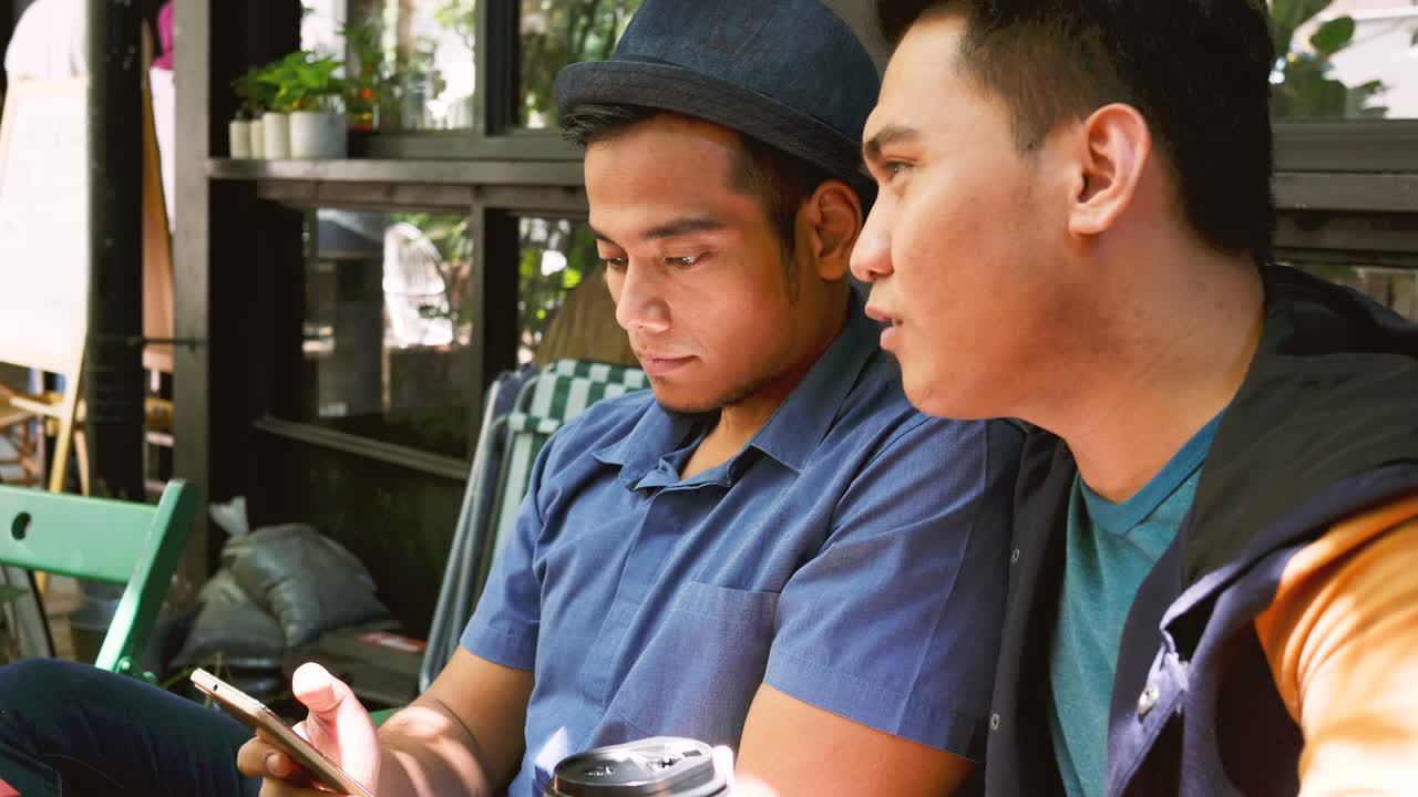 두 남자가 스마트폰을 보고 있다.