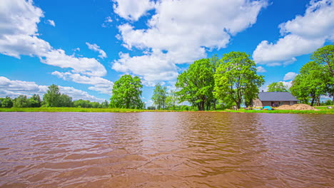 Tiro-De-Timelapse-De-Una-Cabaña-De-Madera-Al-Lado-De-Un-Lago-En-Un-Día-Nublado