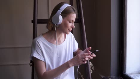 young charming girl listening to music in headphones