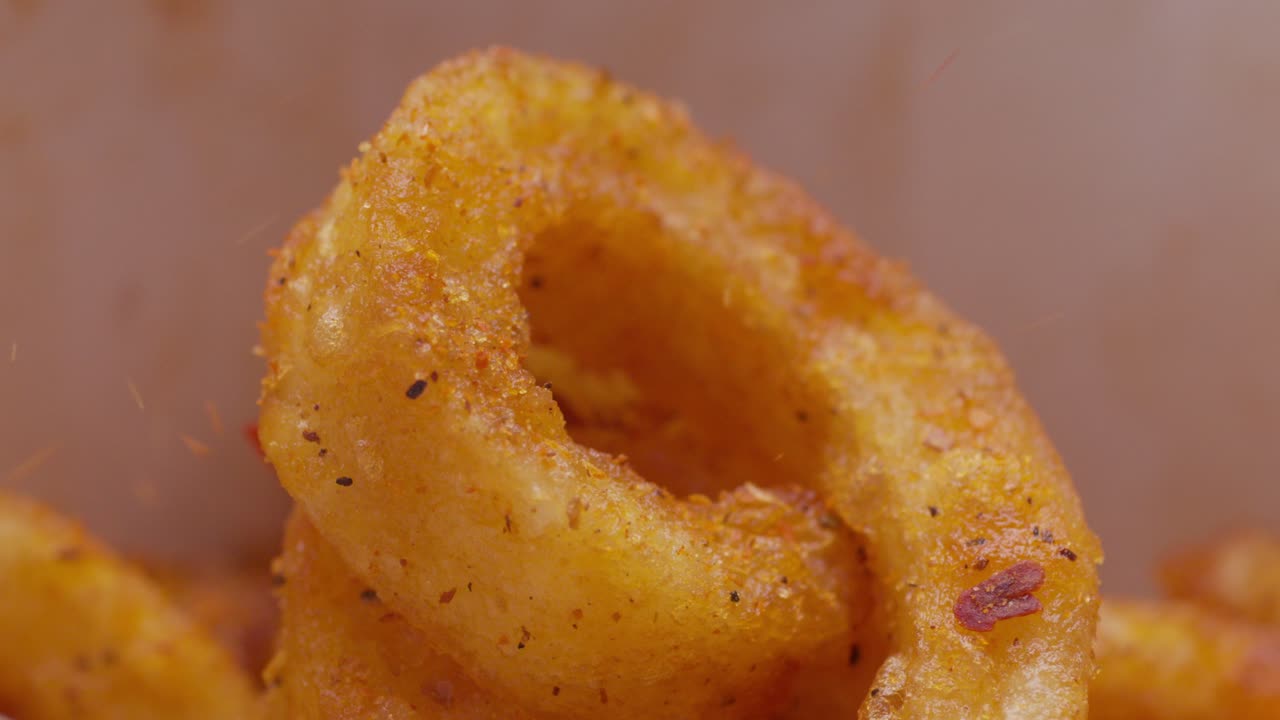 Curly fries covered with seasoning, macro shot of crispy, golden fried food