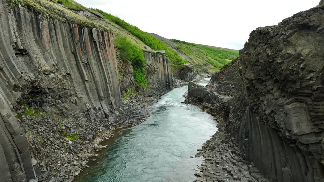 River and basalt columns of Studlagil Canyon in Iceland during sunny day. Aerial view. Rocky Formation after erosion of volcanoes