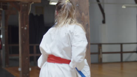 handheld shot of happy girls practicing karate together in gym