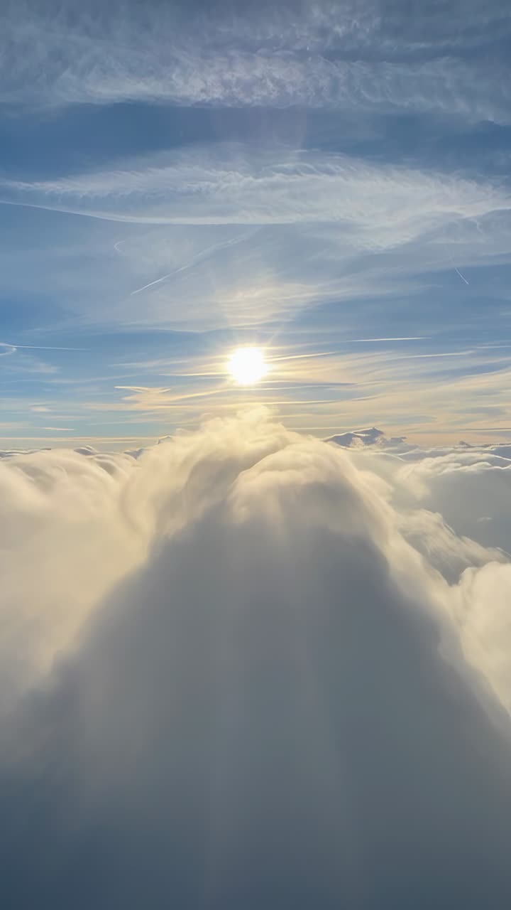 Video verticale: Movimento della piattaforma che avvia la panoramica della telecamera verso un'alta cresta di nuvole sopra il ponte, con il sole.