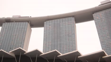 looking up at the futuristic iconic marina bay sands hotel in singapore