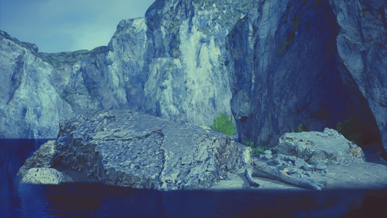 Dramatic rocky landscape with calm water and shadows at twilight