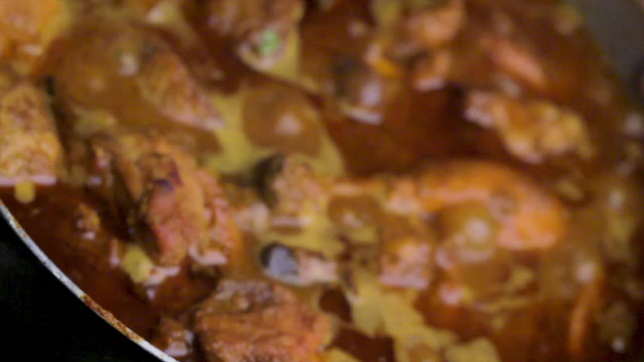 receta casera de pollo picante al estilo indio cocinada en una sartén por el chef, revolviendo el curry de pollo y cocinando la receta de pollo, cocinando comida no vegetariana