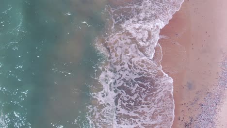 Top-down-aerial-view-of-clean-white-sandy-beach-on-ocean-shore