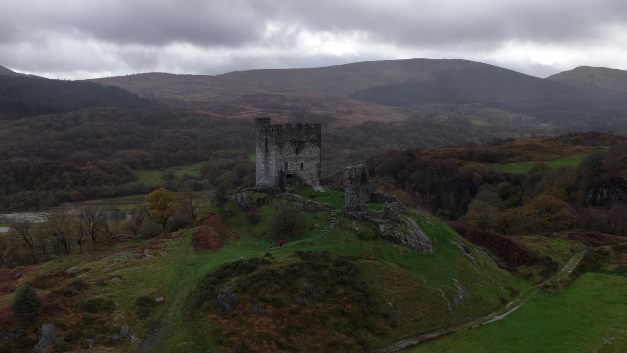Aerial drone video of Dolwyddelan Castle in Snowdonia National Park, showing the medieval hilltop ruins and the dramatic Welsh highland landscape surrounding this historic stronghold