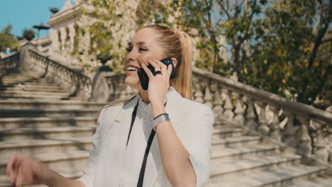 stilvolle junge frau, die draußen am telefon anruft.